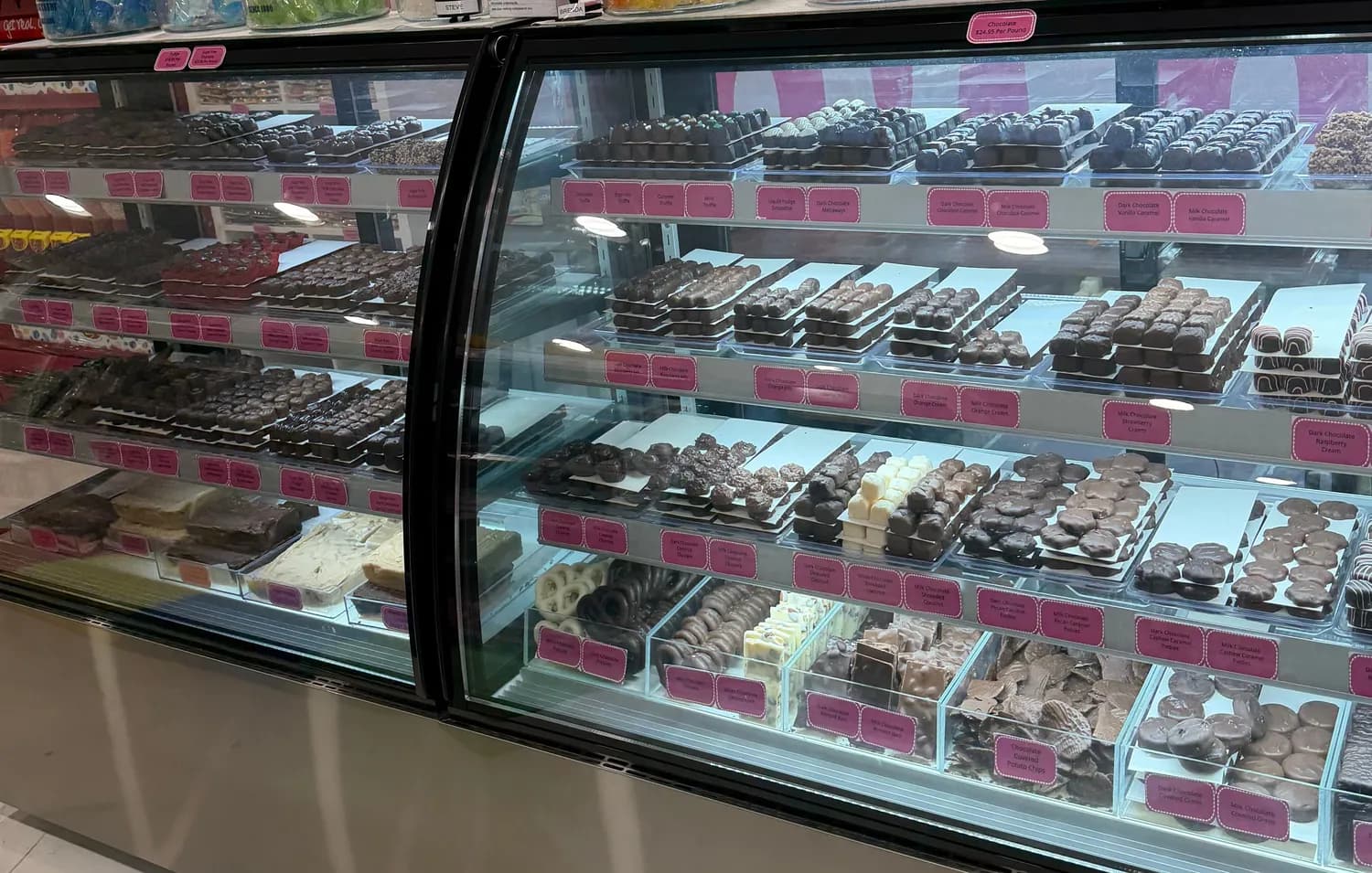 Trays of hand-dipped chocolates in the lit display case at Pearl's