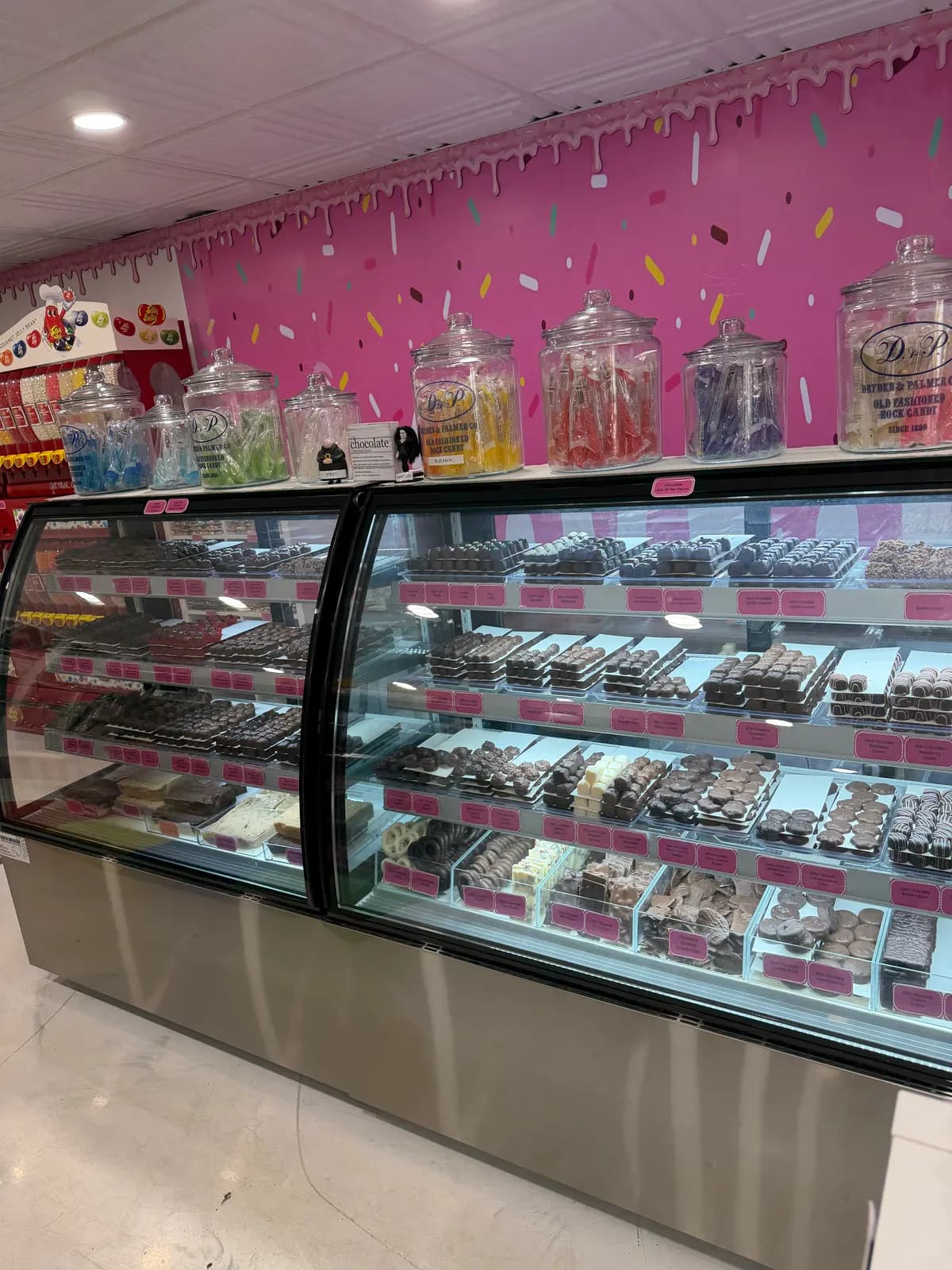 Glass display case filled with rows of chocolates